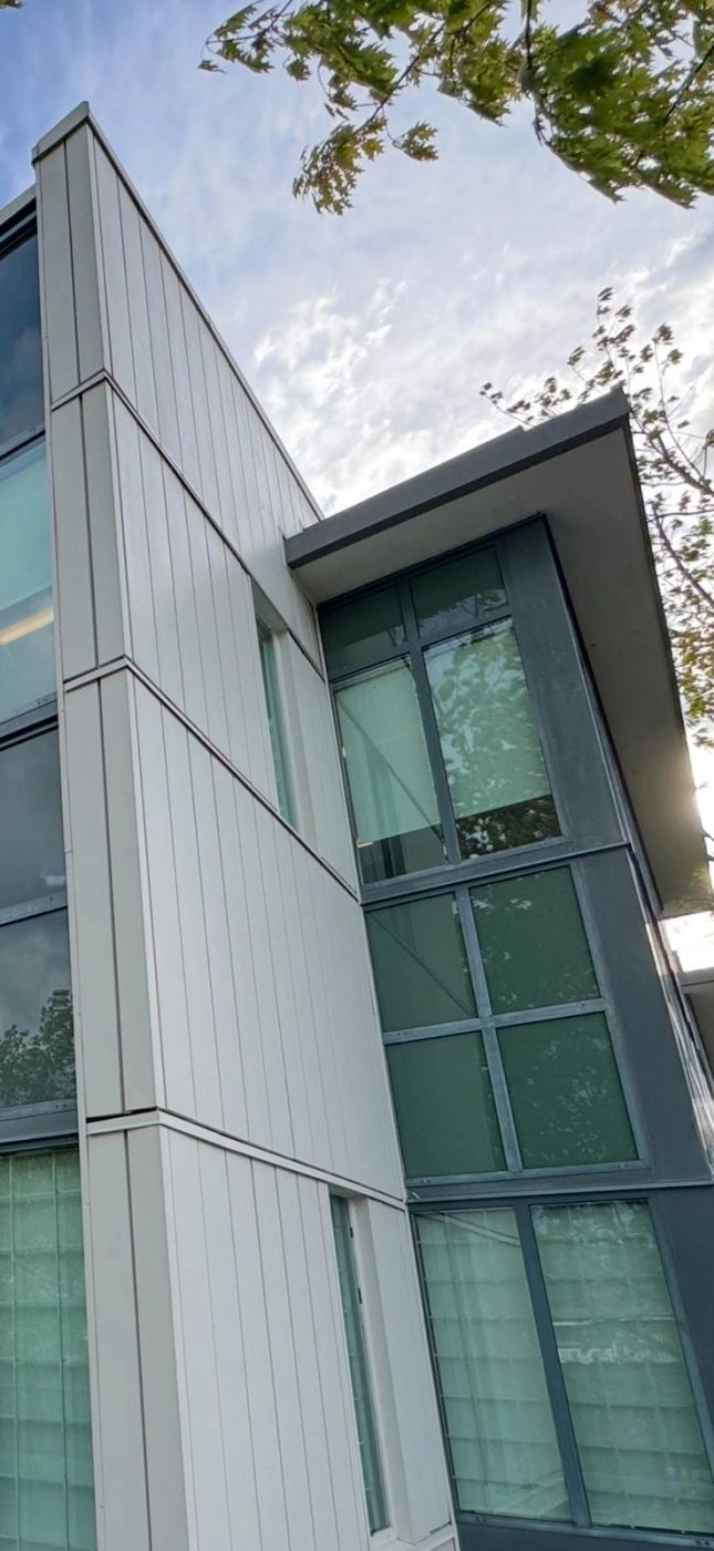 The same building corner after washing, the cladding clean and unstreaked.
